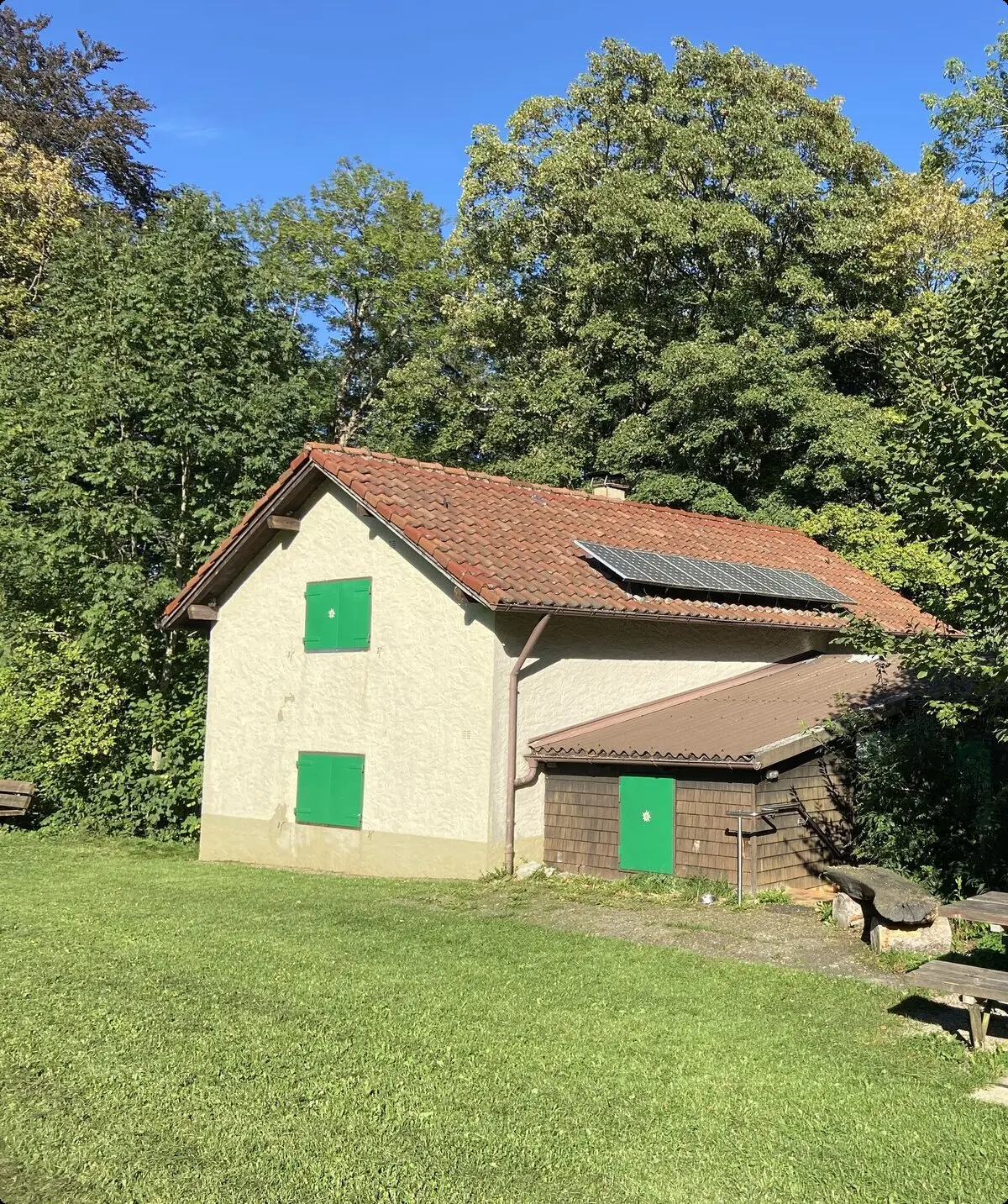 Kreuzberghütte im Sommer mit Sitzgelegenheit im Vordergrund | © DAV/Sektion Hohenstaufen Göppingen