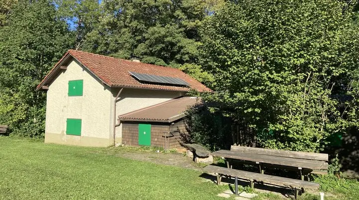 Kreuzberghütte im Sommer mit Sitzgelegenheit im Vordergrund | © DAV/Sektion Hohenstaufen Göppingen