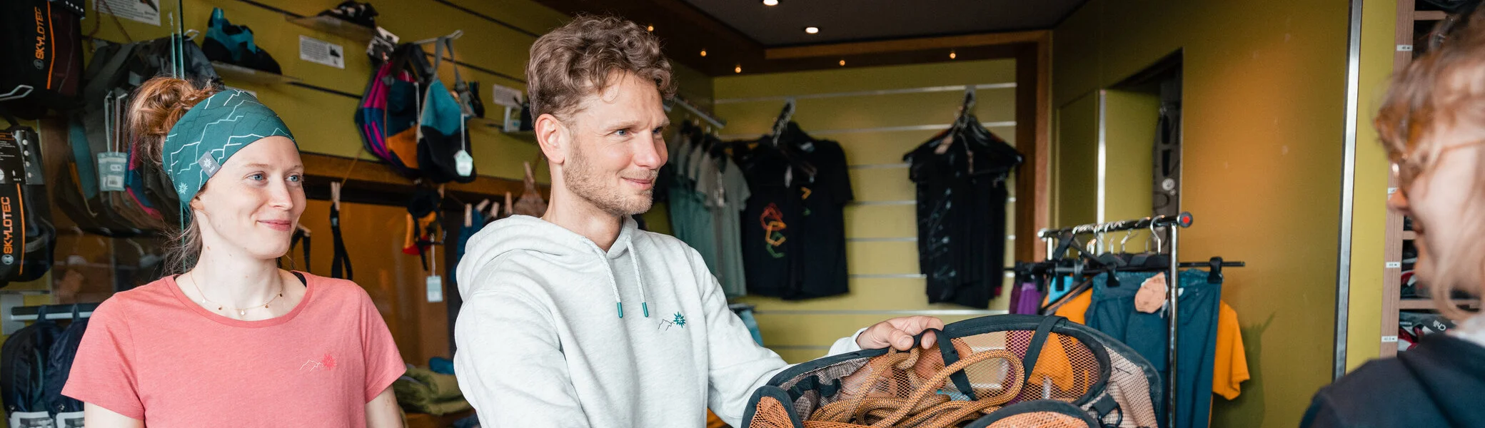 Zwei Personen leihen sich in einer Boulderhalle Ausrüstung aus. | © DAV/Marisa Koch