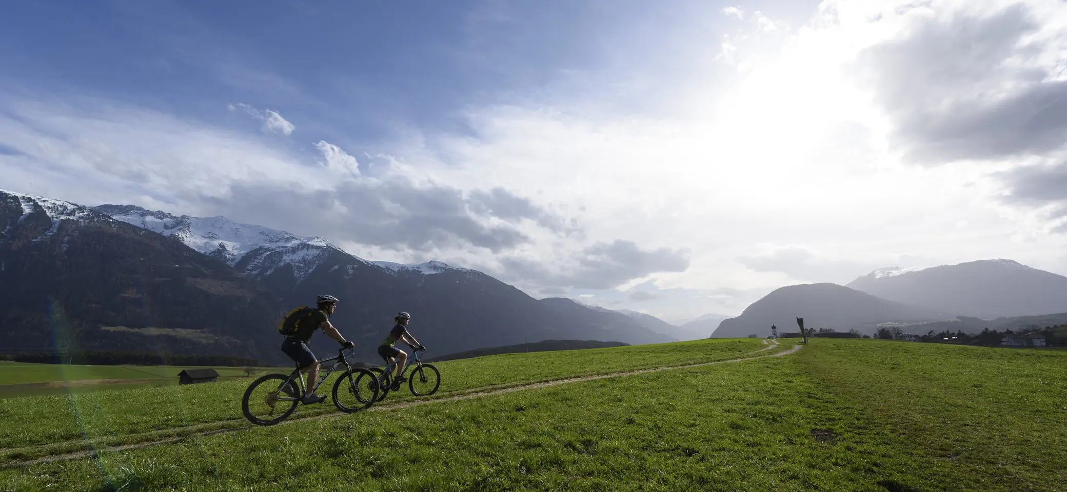 Zwei Mountainbiker auf einer grünen Wiese | © DAV/Wolfgang Ehn